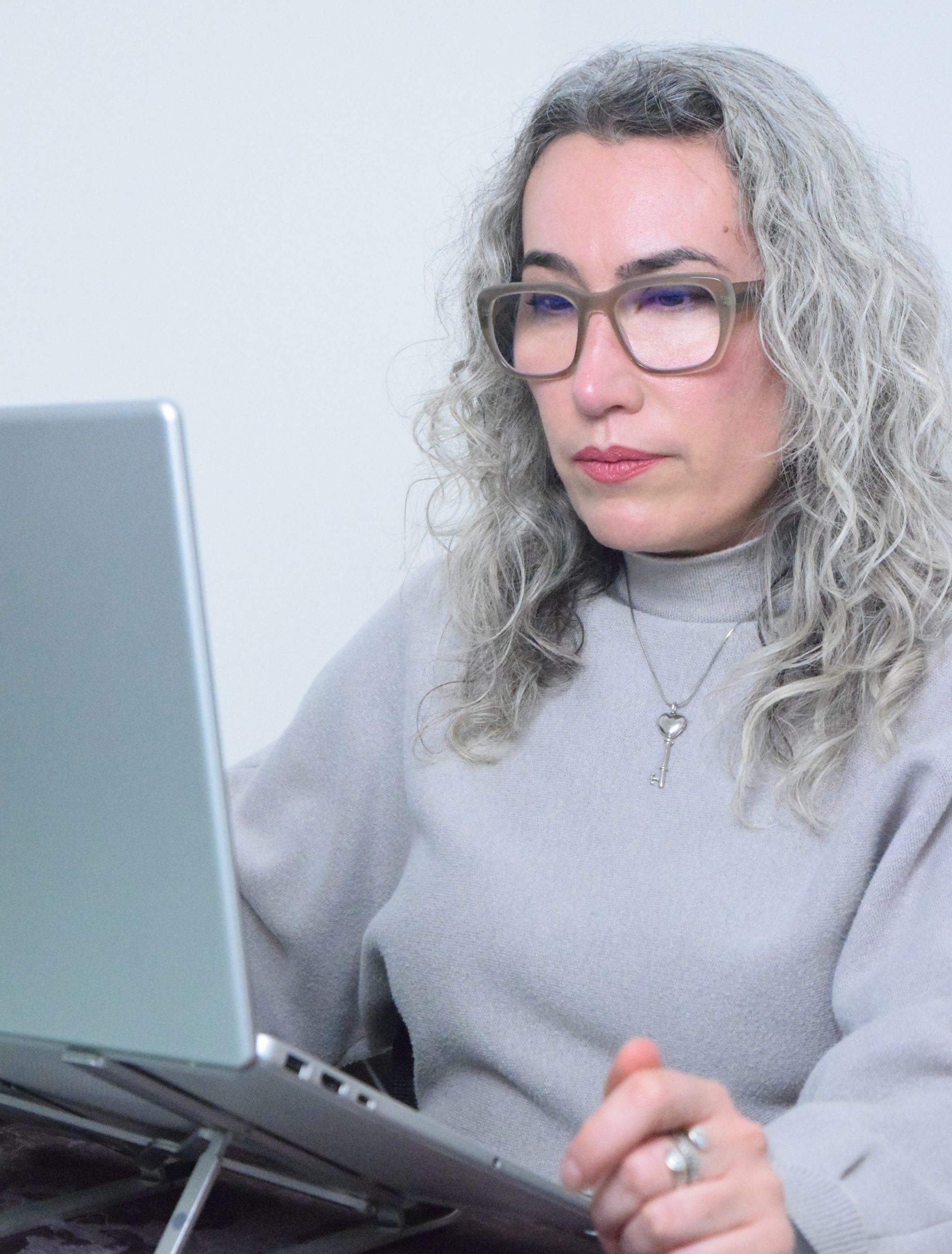 Mujer analizando documentación en su laptop en un entorno profesional. Manglar Consultores.