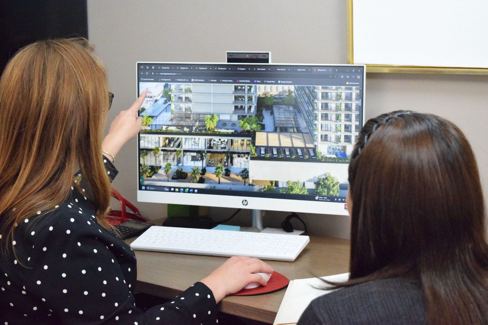 Dos mujeres analizando un modelo arquitectónico digital en una computadora. Manglar Consultores.
